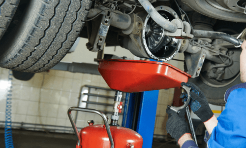 Kfz-Mechaniker repariert Achse eines Fahrzeugs in Autowerkstatt Bremen