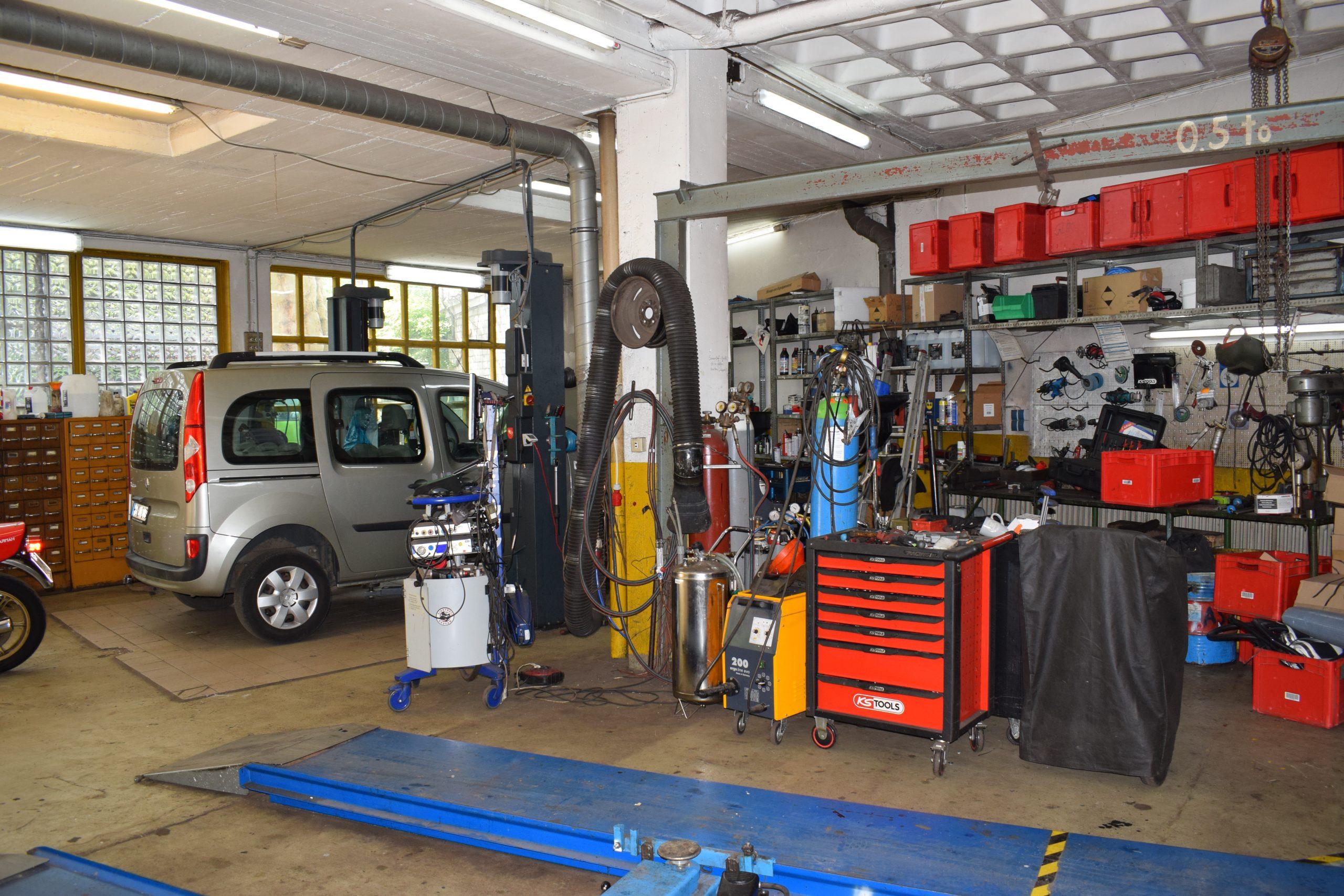 Innenansicht der Timm & Golz Autowerkstatt mit Fahrzeug und moderner Werkstattausstattung Silbernes Auto in Autowerkstatt Bremen, umgeben von Werkzeugen und moderner Technik