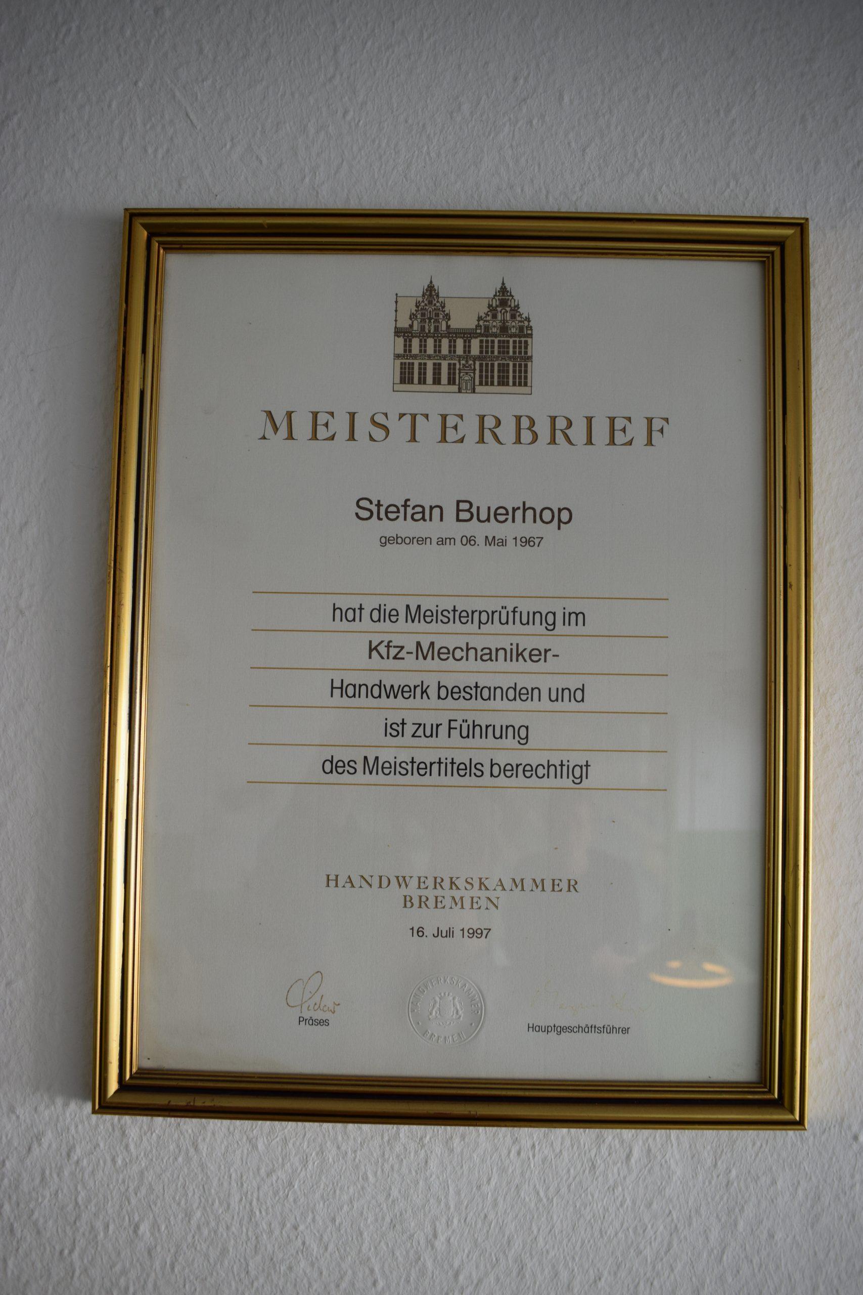Meisterbrief im Kfz-Mechaniker-Handwerk im goldenen Rahmen an weißer Wand Meisterbrief Kfz-Mechaniker Handwerkskammer Bremen im goldenen Rahmen an Wand