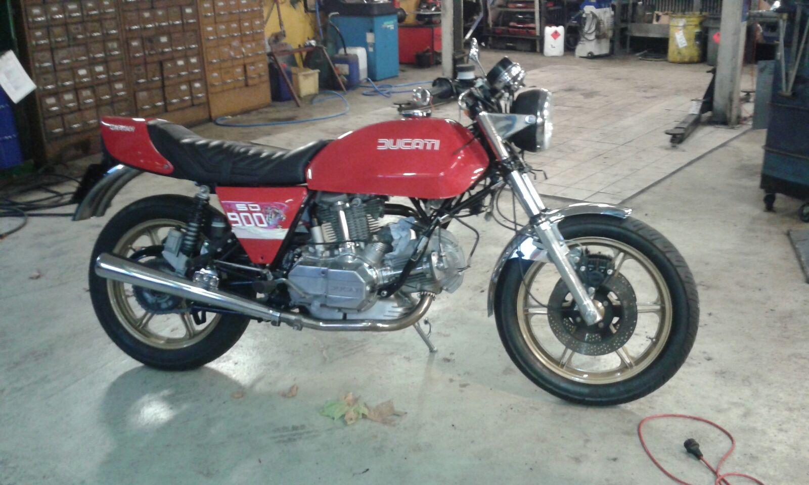 Rotes Ducati Motorrad SD 900 in Autowerkstatt mit Werkbankschubladen im Hintergrund Rotes Ducati Motorrad in Autowerkstatt Bremen vor Werkbänken und Werkzeugschränken
