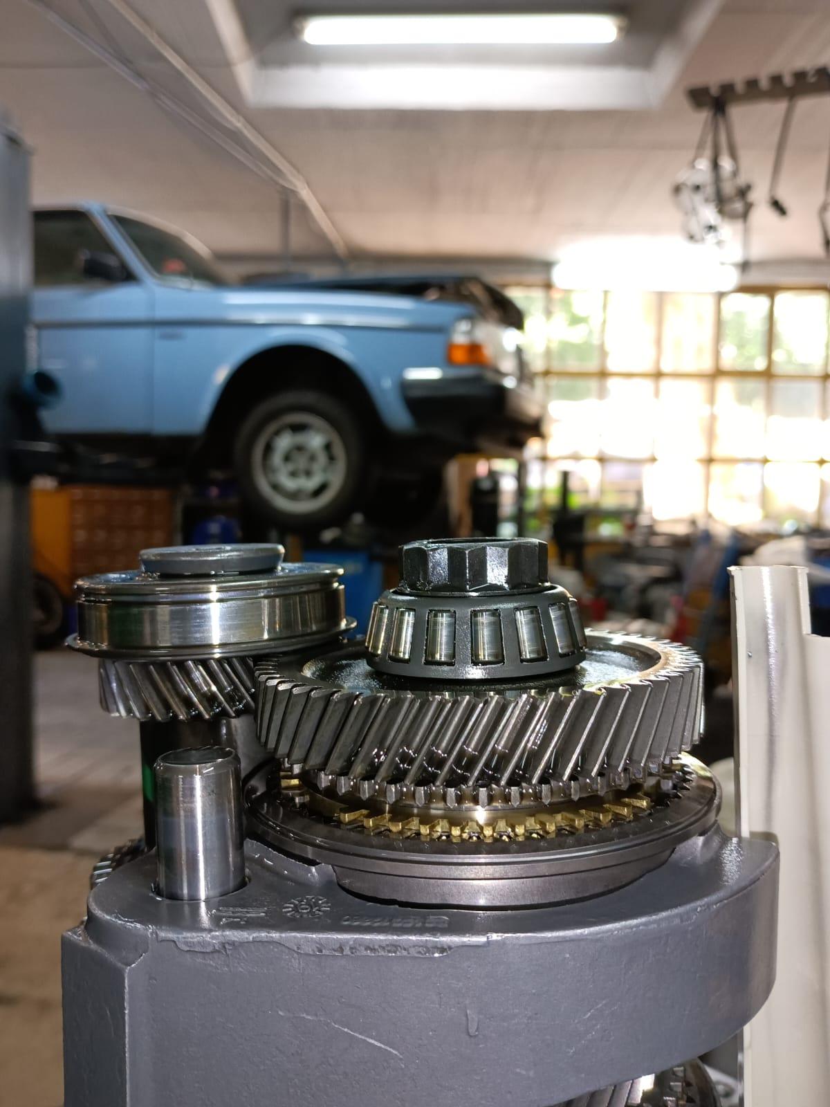Detailaufnahme eines Getriebes mit Hebebühne und klassischem Auto in Kfz-Werkstatt Getriebe und Auto auf Hebebühne in der Autowerkstatt Bremen